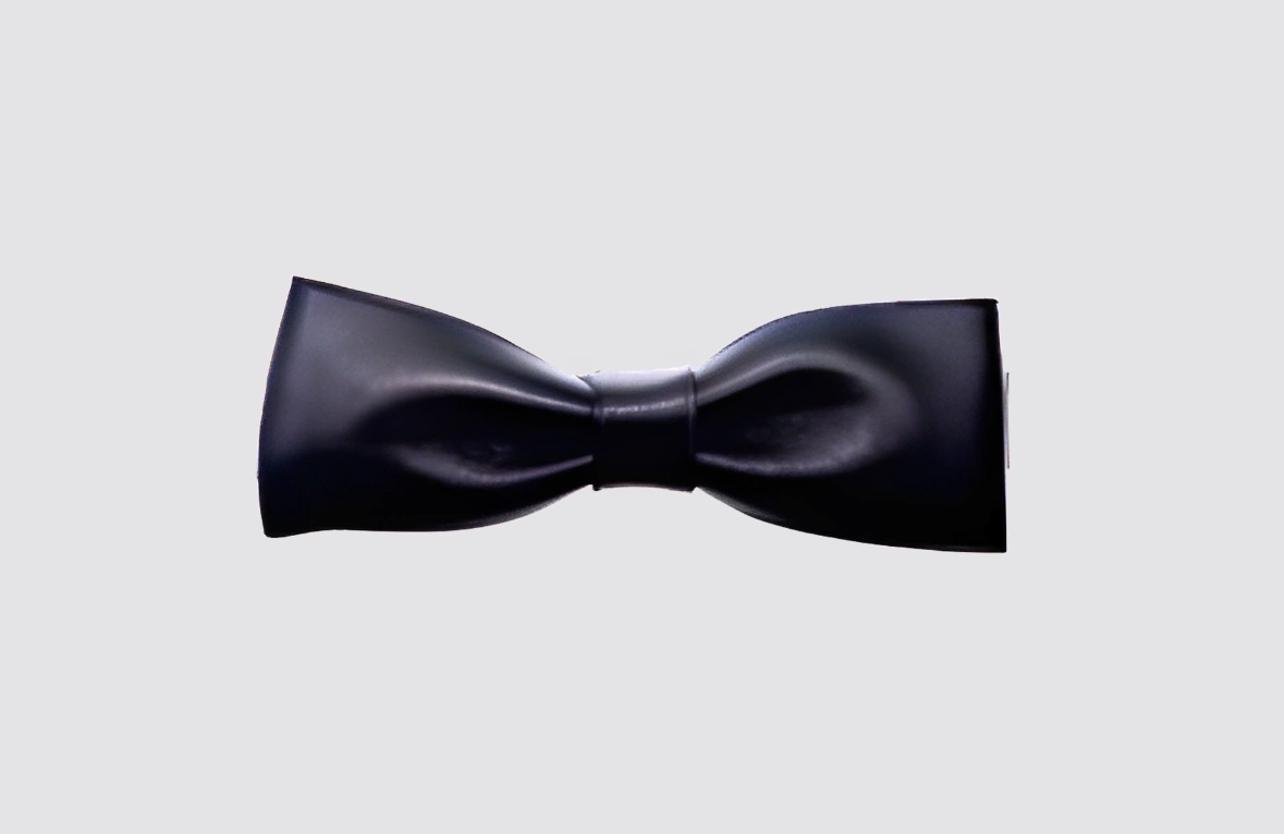 Nœud papillon en cuir de chevreau noir, confectionné à la main, élégant et audacieux. Sobriété et caractère se mêlent pour sublimer vos tenues, avec système réglable et fermeture par pression pour un confort optimal. Accessoire artisanal original et raffiné, idéal pour soirées, mariages et événements.