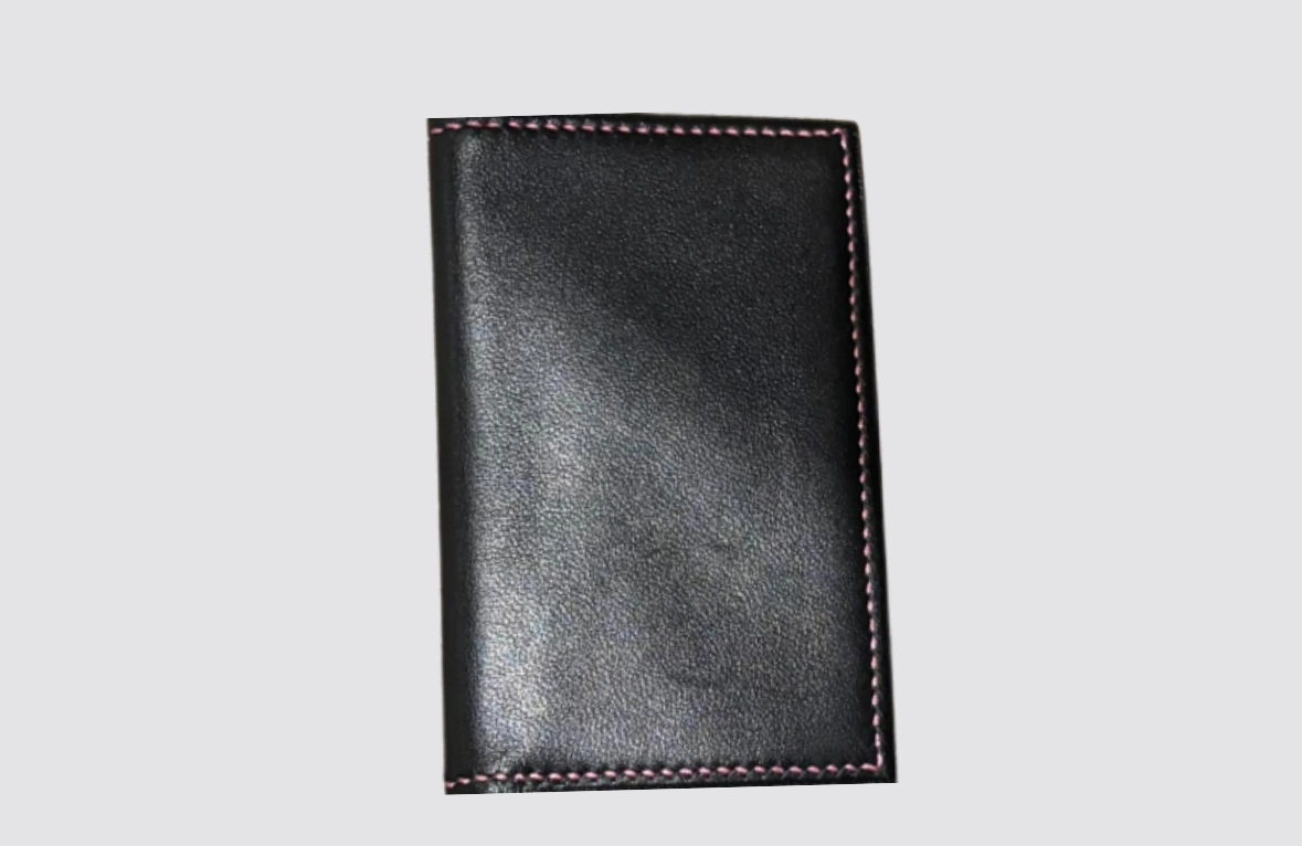 Porte-feuille en cuir artisanal fermé, élégant et raffiné, confectionné à la main avec cuir de chevreau noir et doublure en agneau rose, coutures contrastantes soignées. Compact et pratique, il protège vos cartes et petits essentiels tout en reflétant sobriété, féminité et savoir-faire artisanal.