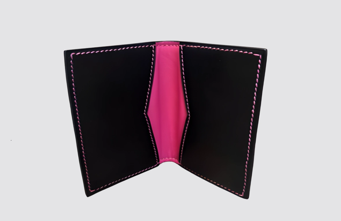 Porte-cartes en cuir artisanal, élégant et raffiné, confectionné à la main avec cuir de chevreau noir et doublure en agneau rose, coutures contrastantes soignées. Compact et pratique, il accueille 2 à 4 cartes et allie sobriété, féminité et savoir-faire artisanal.