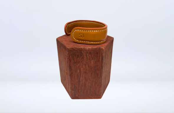 Bracelet en cuir de luxe pour homme, vue de profil sur support bois.