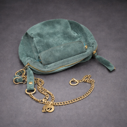 Problème de structure et de fermeture sur une sacoche en cuir vert avant intervention technique.