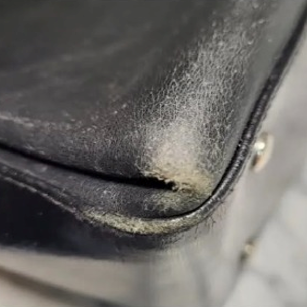 Zoom sur les angles usés d'un sac en cuir bleu avant sa restauration chez Maison Alibert en Isère.