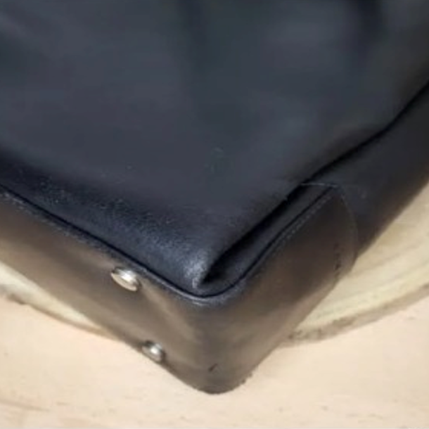 Résultat final de la restauration cuir artisanale sur les angles d'un sac à main bleu.